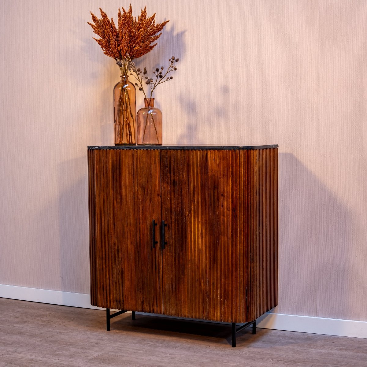 Brauner Holzschrank mit vertikalen Rillen und zwei Türen.