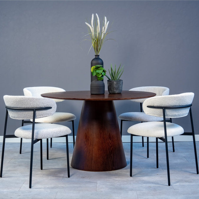 Runder dunkelbrauner Holztisch mit vier weißen Stühlen.