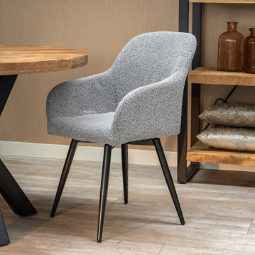 Grauer Stoff-Esszimmerstuhl mit schwarzen Beinen.