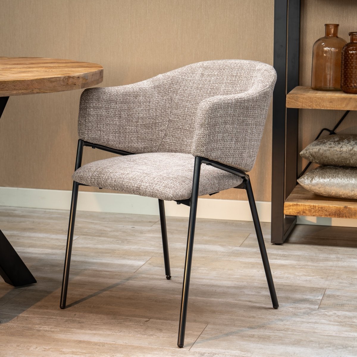 Beiger Esszimmerstuhl mit schwarzen Beinen.