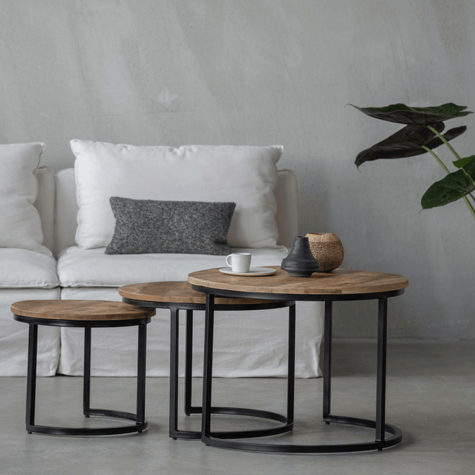 Set aus drei runden Couchtischen aus Holz mit schwarzem Metallgestell.