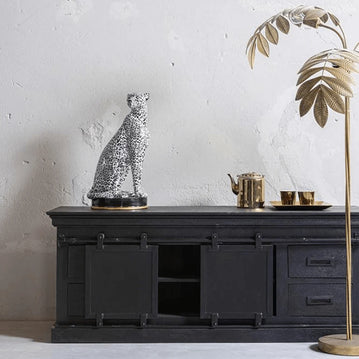 TV-Möbel aus Holz mit schwarzer Schiebetür. 