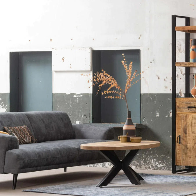 Graues Sofa mit einem Couchtisch aus Holz mit schwarzen Metallbeinen.