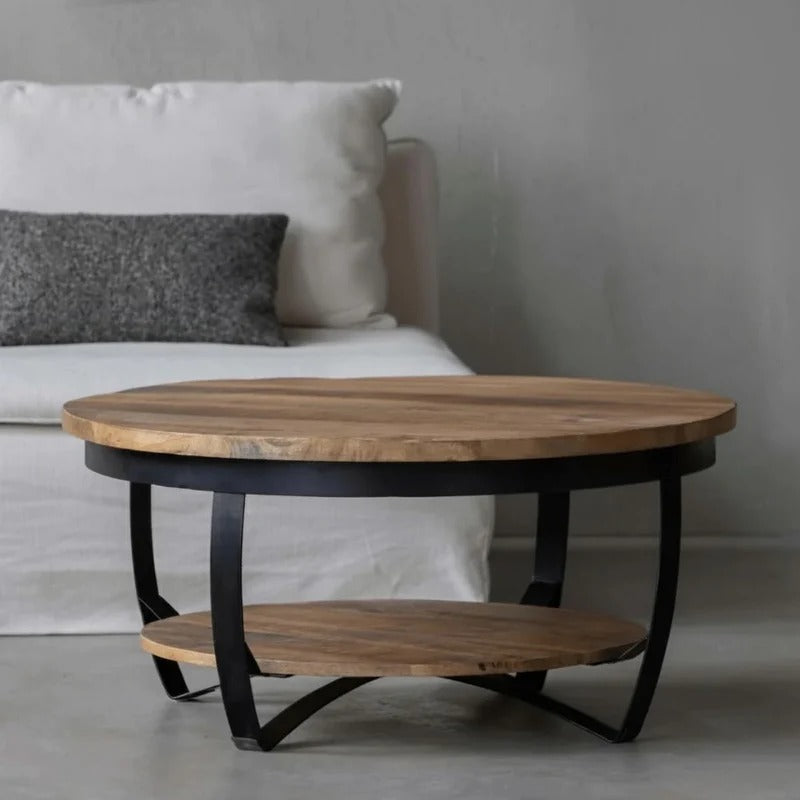 Runder Couchtisch mit schwarzen Metalldetails.