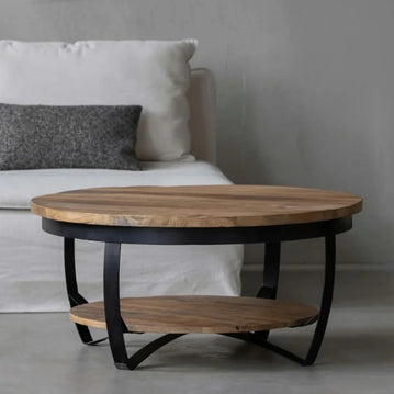 Runder Couchtisch mit schwarzen Metalldetails.